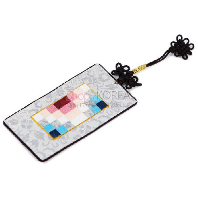 은색 바탕 비단에 전통 조각보 패치워크가 더해지고 흑색 매듭끈 장식이 연결된 직사각형 책갈피. 은색 바탕 비단에 전통 조각보 패치워크가 더해지고 흑색 매듭끈 장식이 연결된 직사각형 책갈피.