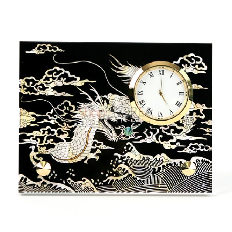 검은 옻칠 바탕에 자개 상감으로 용과 구름, 파도 문양을 장식한 금색 테두리 원형 시계.