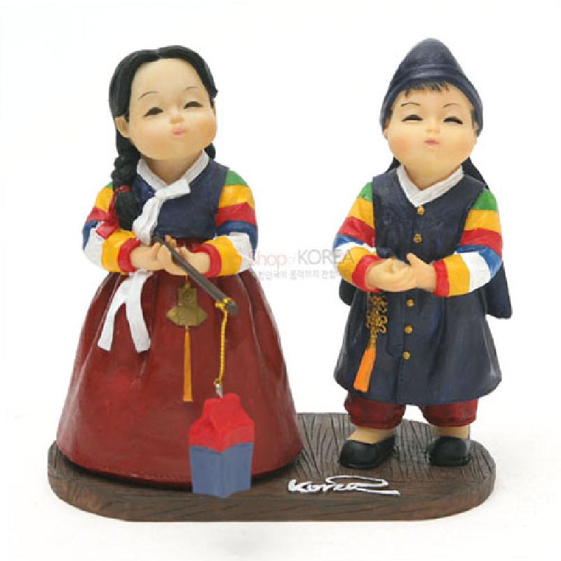 채색 수지 재질로 표현한 한복 차림 남녀 인형과 손에 든 청사초롱 장식, 오방색 소매와 단아한 전통 문양이 특징인 조형 장식품.