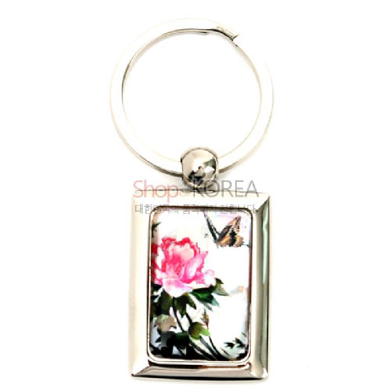 금속 테두리에 자개 판을 상감하여 담홍색 꽃과 나비 문양을 담은 사각형 열쇠고리.
