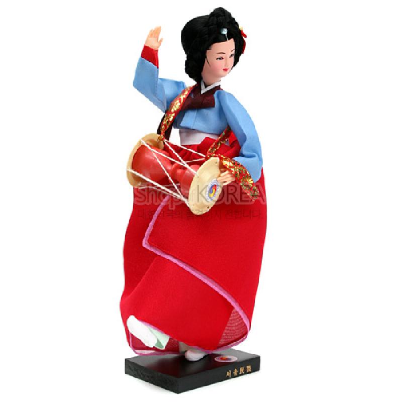 붉은 치마와 하늘색 저고리의 비단 한복, 꽃무늬 금박 띠와 장구를 들고 있는 전통춤 한복 인형.
