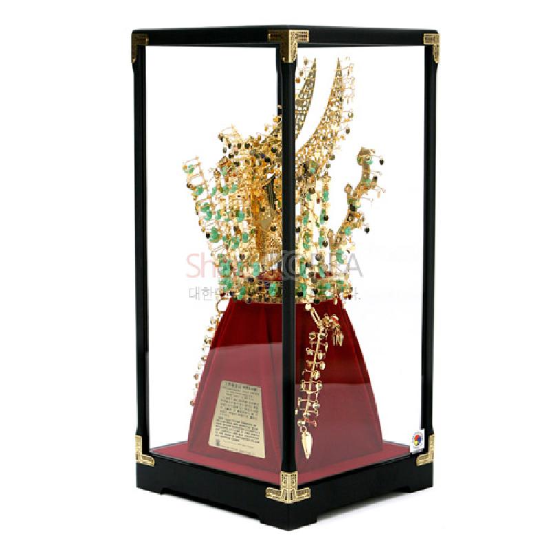 금속으로 제작된 금관을 녹색 장식 보석과 금색 장식으로 표현한 천마총 금관 모형 장식.