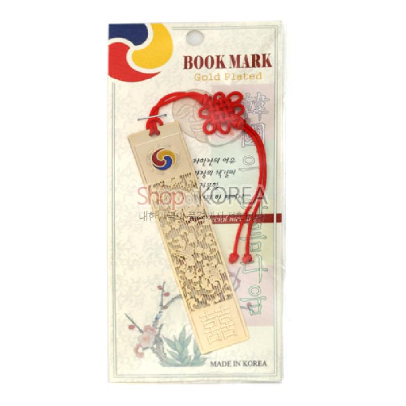 금장 금속 재질 위에 당초문과 수복문을 음각한 직사각 책갈피, 상단 태극 문양과 붉은 전통 매듭 끈 장식.