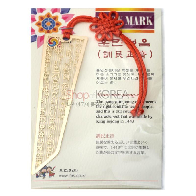금속 재질에 훈민정음 글귀를 양각한 책갈피와 붉은색 전통 매듭 장식이 돋보이는 디자인.
