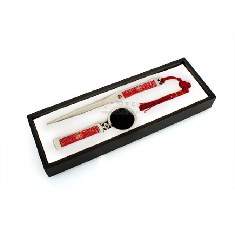 붉은색 전통 희문 문양이 새겨진 금속 북커버, 책갈피, 손거울로 구성된 사무용 3종 세트.