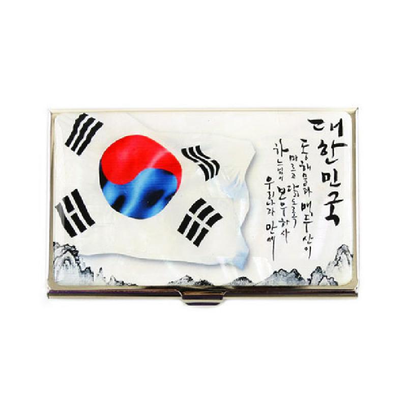 메탈 소재 위 태극기 문양과 한글 서예, 흑백 산수화가 인쇄된 직사각형 명함집.