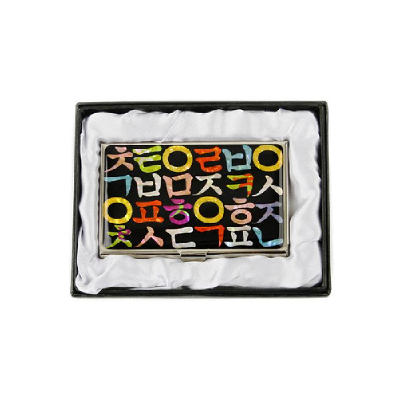 검은 바탕 위에 다채로운 한글 자모를 상감한 금속 명함집, 화려한 색채 대비가 돋보이는 디자인.