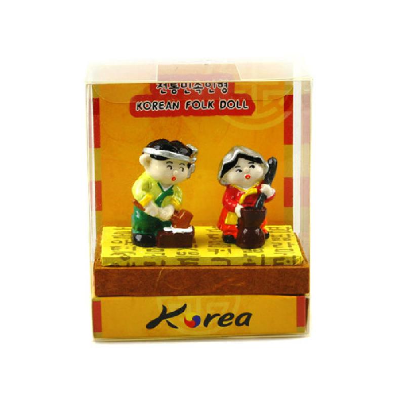 화려한 원색의 한복을 입은 절구질 남매를 표현한 도자 재질 민속 인형 장식.