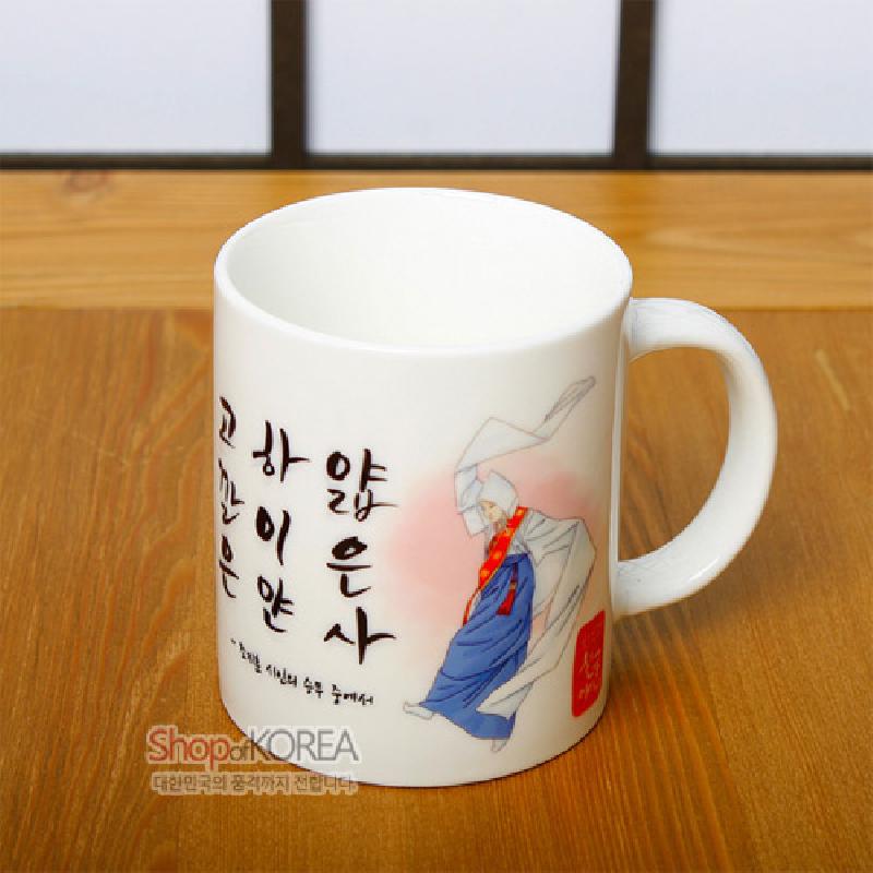 백자 느낌의 흰 머그컵에 승무를 추는 인물 일러스트와 붉은 그라데이션, 검은 한글 서체가 어우러진 디자인.
