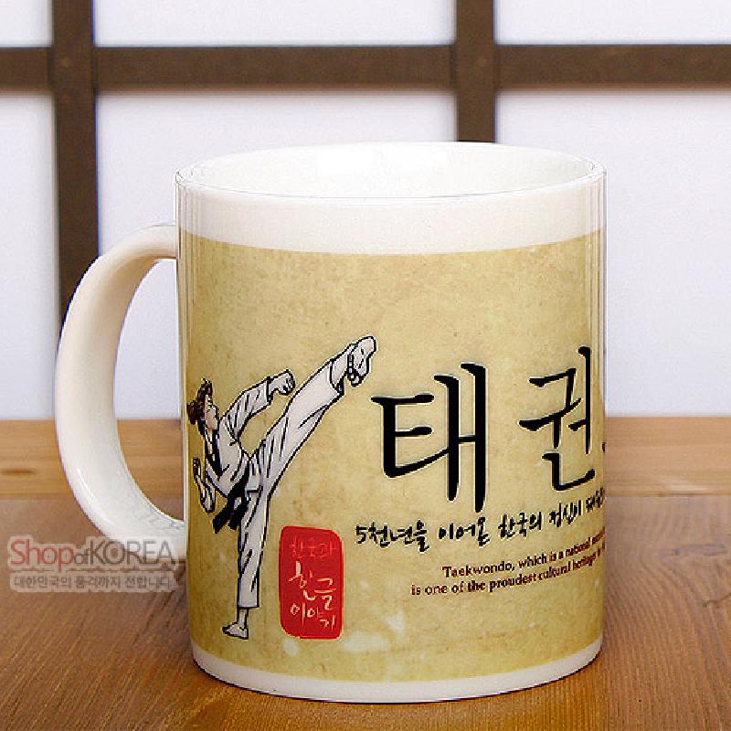 백색 도자 재질에 태권도 동작 일러스트와 한글 서체, 붉은 낙관 스타일 포인트가 인쇄된 머그컵.