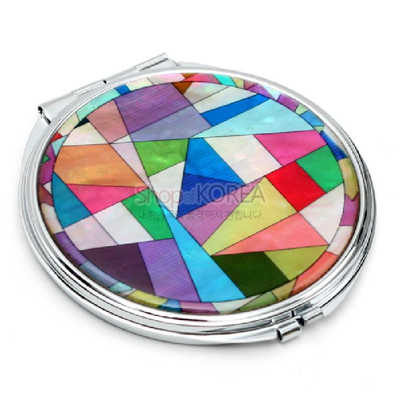 은빛 금속 테두리에 다채로운 색상의 자개를 상감해 조각보 기하학 문양을 표현한 원형 손거울.