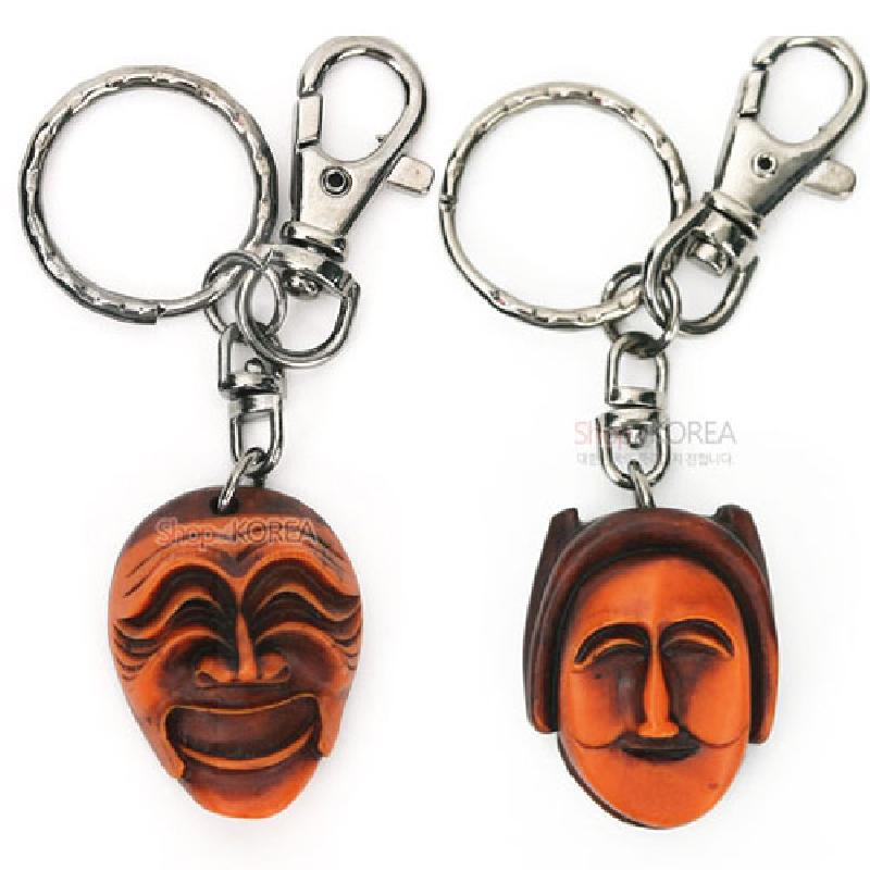 나무 재질로 조각된 양반·부네 탈 형상의 열쇠고리, 갈색과 주황색 대비 색감과 금속 고리 장식이 특징인 제품. 나무 재질로 조각된 양반·부네 탈 형상의 열쇠고리, 갈색과 주황색 대비 색감과 금속 고리 장식이 특징인 제품.