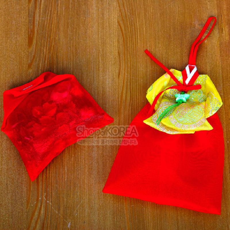 붉은 비단 재질 주머니에 황색과 연두색 전통 문양 천을 겹친 당의 형태의 향주머니, 중앙 매듭 장식이 돋보이는 구성. 붉은 비단 재질 주머니에 황색과 연두색 전통 문양 천을 겹친 당의 형태의 향주머니, 중앙 매듭 장식이 돋보이는 구성.