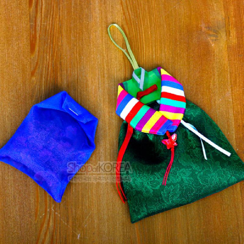 녹색 꽃문양 비단에 색동저고리 모양 배색과 끈 매듭 장식이 어우러진 전통 향 주머니.