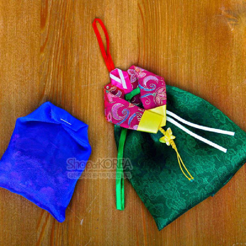 녹색 잎사귀 문양 비단치마와 분홍색 꽃무늬 저고리 장식이 조화된 한복 형상의 전통 벽걸이 향주머니.