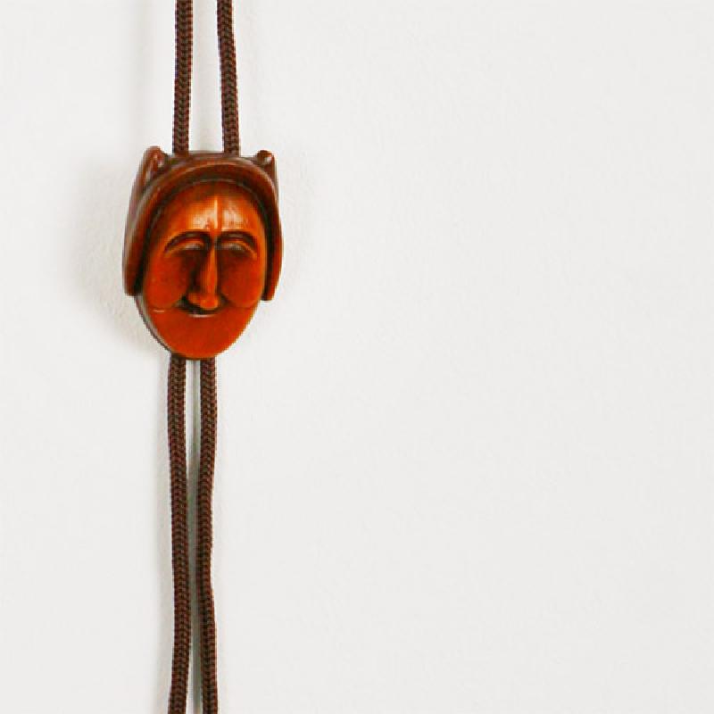 나무 재질로 조각한 전통 부네탈 장식과 갈색 끈으로 구성된 간결한 디자인의 로프타이.