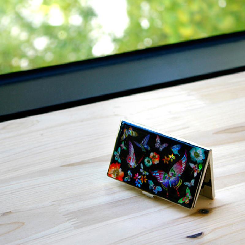 검은 바탕에 자개 상감 기법으로 호랑나비와 꽃 문양을 표현한 금속 명함케이스.