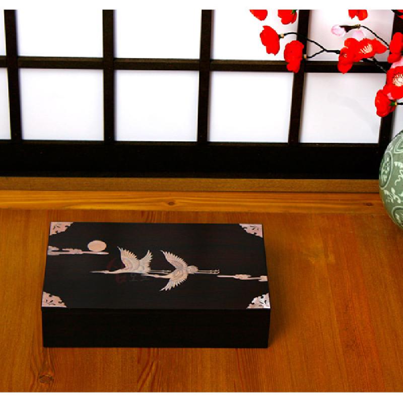 검은 옻칠 표면에 자개 상감 기법으로 학과 구름, 달 문양을 새긴 직사각형 목함.