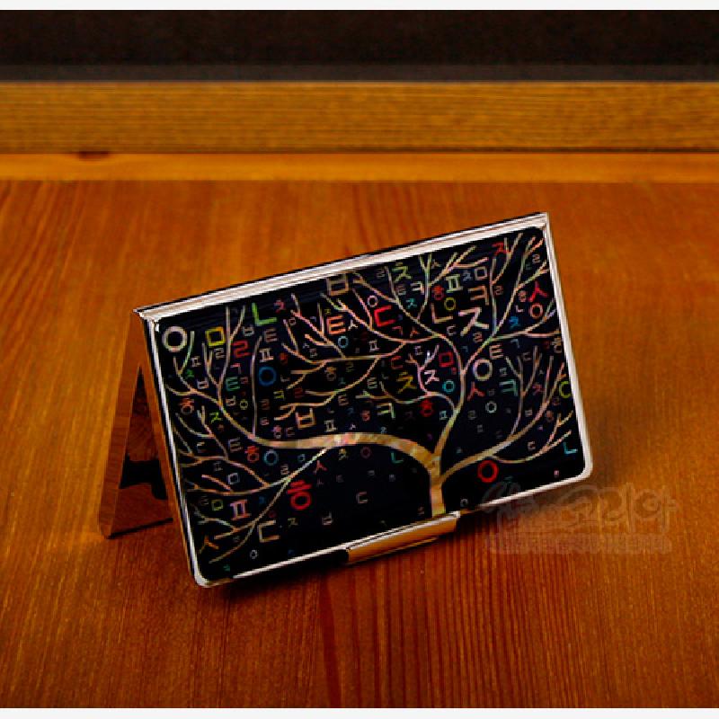 검은 바탕에 자개 상감 기법으로 나무와 형형색색 한글 자모 문양을 넣은 금속 명함집.