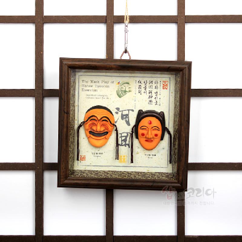 나무 질감 사각 액자에 오렌지색 하회탈 입체 부조와 한지 바탕의 서예 문양이 조화된 전통 장식.