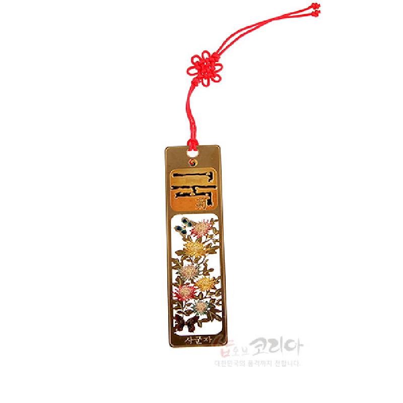 금장 금속 소재에 국화와 나비 문양을 정교하게 새긴 직사각형 책갈피, 붉은 매듭끈 장식의 디자인.