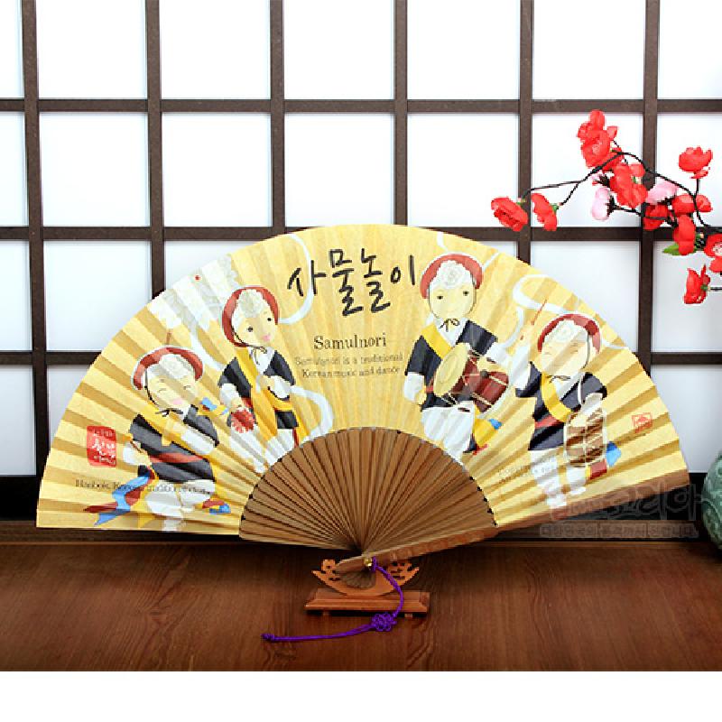 사물놀이 연주자 일러스트와 한글 글씨가 인쇄된 종이 부채, 나무 살과 받침대가 조화를 이룬 전통 부채.