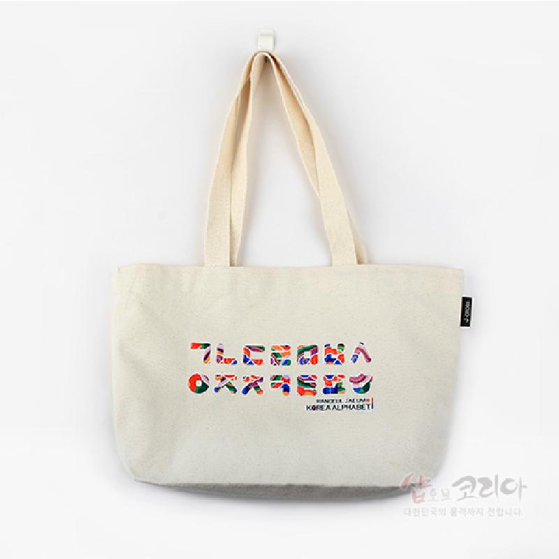 아이보리색 면 소재에 여러 색상 패턴으로 표현된 한글 자모 입체발포 프린팅이 특징인 에코백.