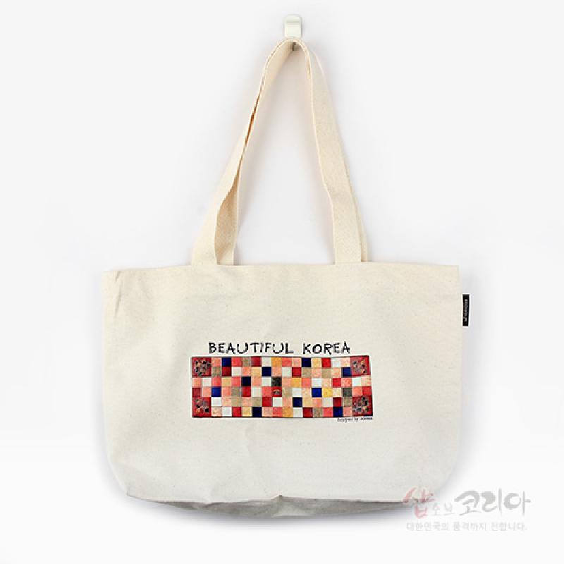 아이보리색 캔버스 천에 다채로운 색상의 조각보 격자 문양을 입체발포로 인쇄한 에코백.