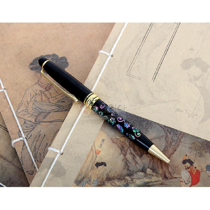 검은 옻칠 바탕에 자개 상감으로 표현한 다채로운 당초무늬와 금색 금속 장식이 조화로운 고급 볼펜.