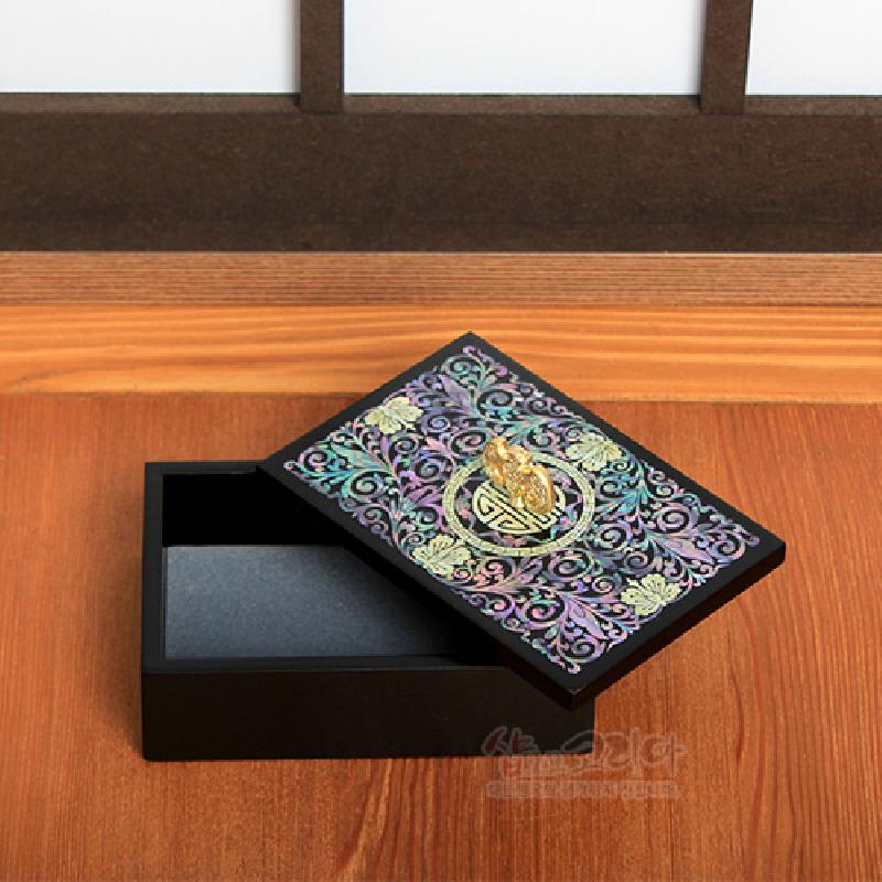 검은 옻칠 바탕 위 자개 상감 당초문과 금색 박쥐 손잡이 장식이 돋보이는 명함함.