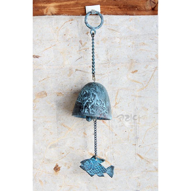 청색 계열 금속 재질로 제작된 벽걸이 풍경종, 종 표면의 벼타작 부조 문양과 물고기 장식이 달린 체인 구성이 특징인 인테리어 소품.