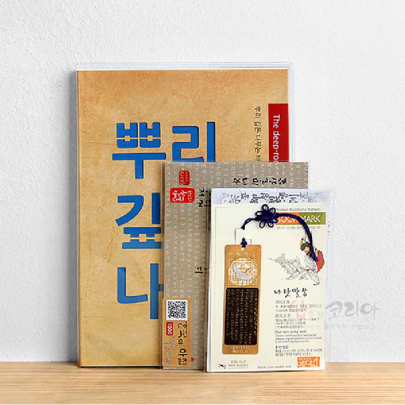 한글 서체 패턴 배경의 만년다이어리와 금속 재질 한글 상감 책갈피, 매듭 장식 끈이 포함된 세트 구성.