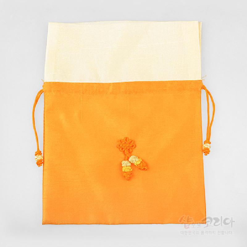 황색과 아이보리 배색의 비단 천으로 만든 복주머니, 중앙에 오렌지·노랑 매듭술 장식이 특징인 끈 조임식 주머니.