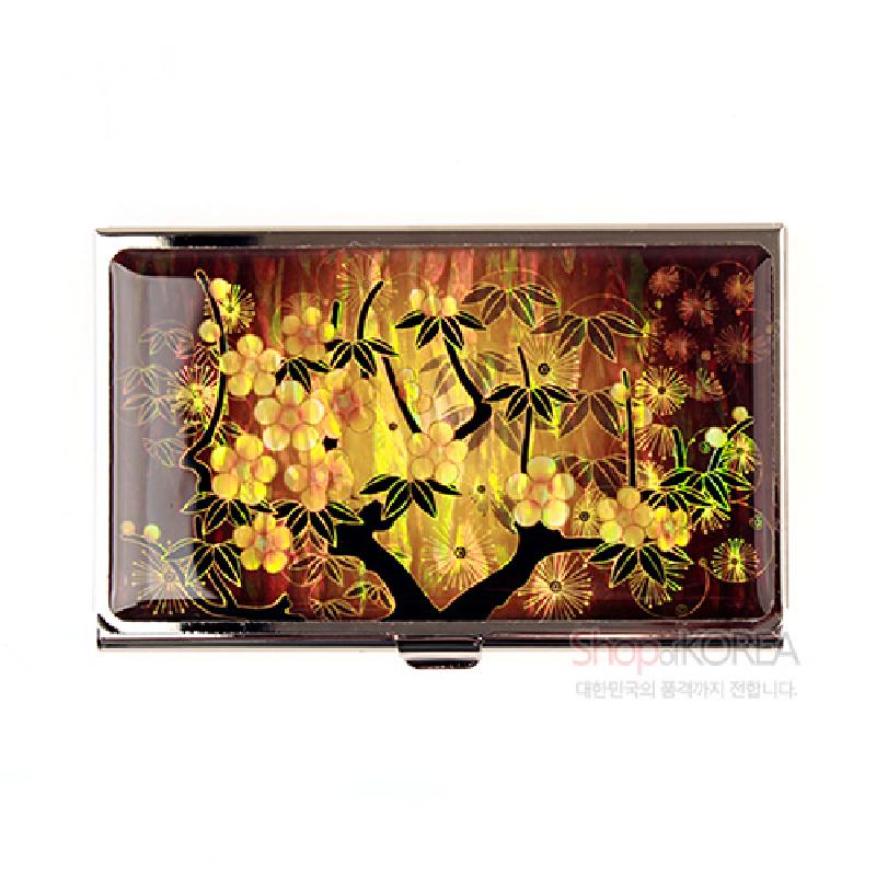 황색 바탕 위 자개 상감 기법으로 매화와 잎사귀 문양을 넣은 금속 테두리 명함케이스.