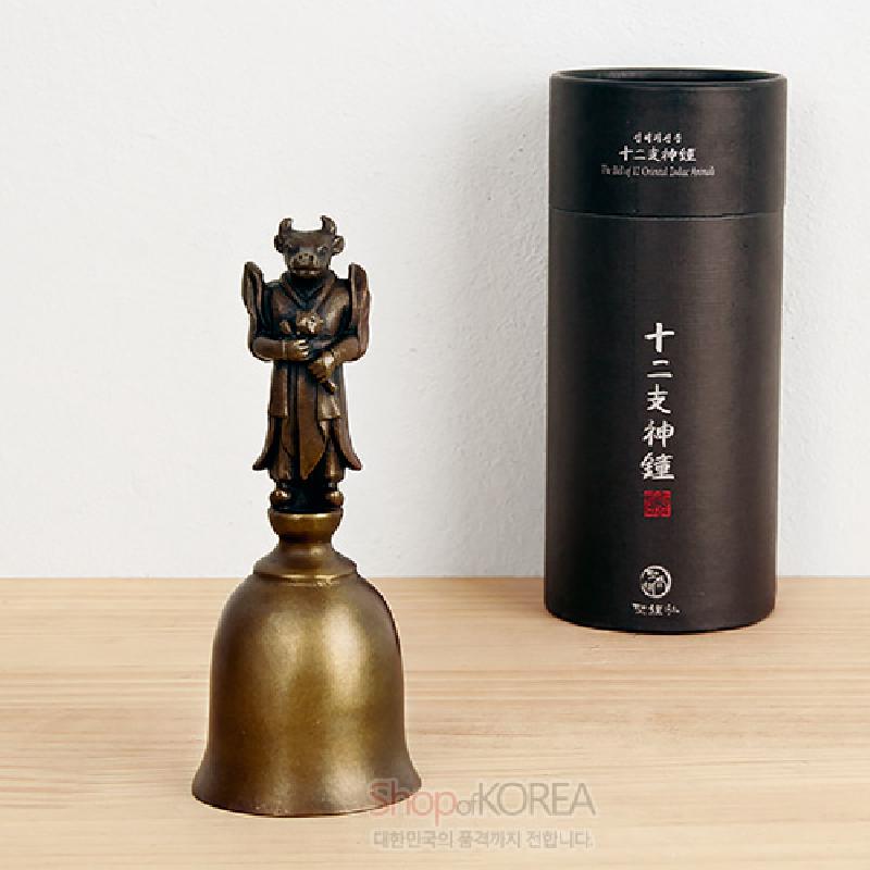 청동 재질의 종 위에 소 머리와 robes 복장을 한 12지신 인물 조각이 올려진 금빛 장식 종.