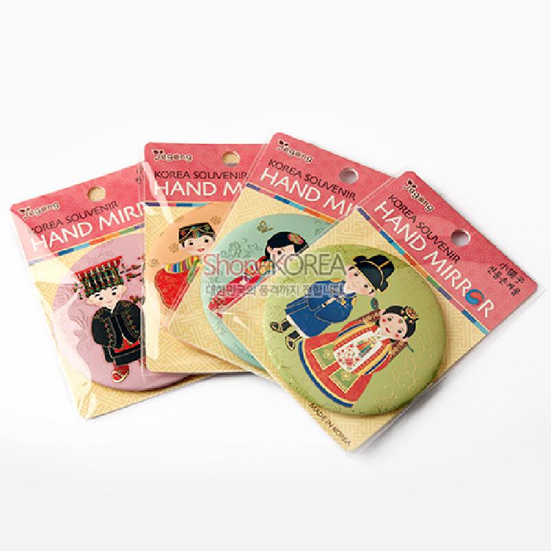 전통 예복을 입은 인물 일러스트가 인쇄된 금속 원형 손거울, 파스텔톤 배경과 단아한 전통 문양이 어우러진 디자인.