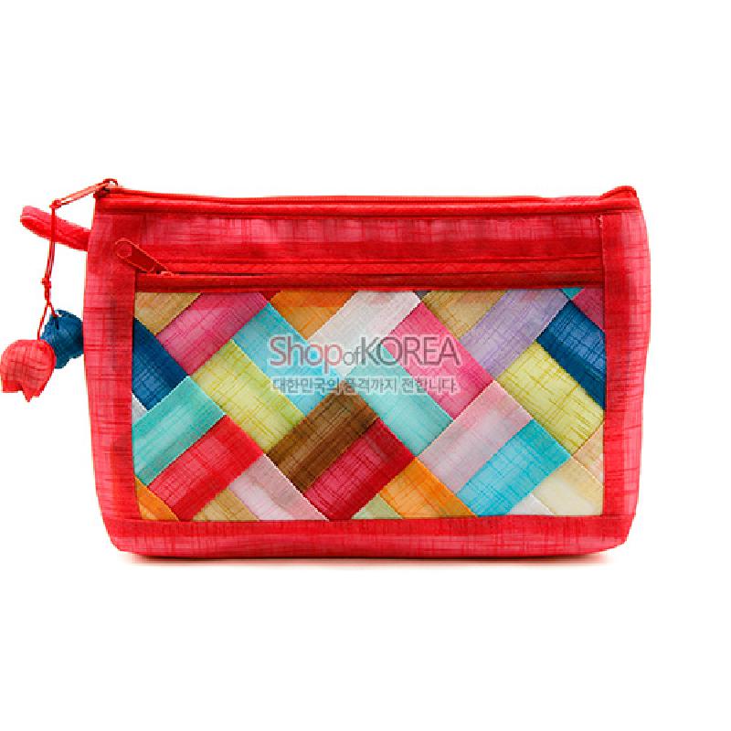 적색 모시 바탕에 다채로운 색상의 조각보 누비 패턴이 들어간 파우치, 옆면 실타래 장식 매듭 포인트.