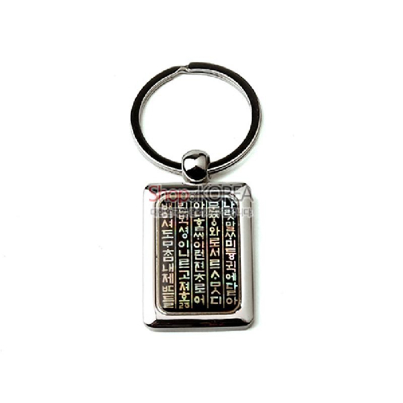 금속 테두리에 자개 상감 기법으로 한글 훈민정음 글귀를 세로 배열한 사각 열쇠고리.