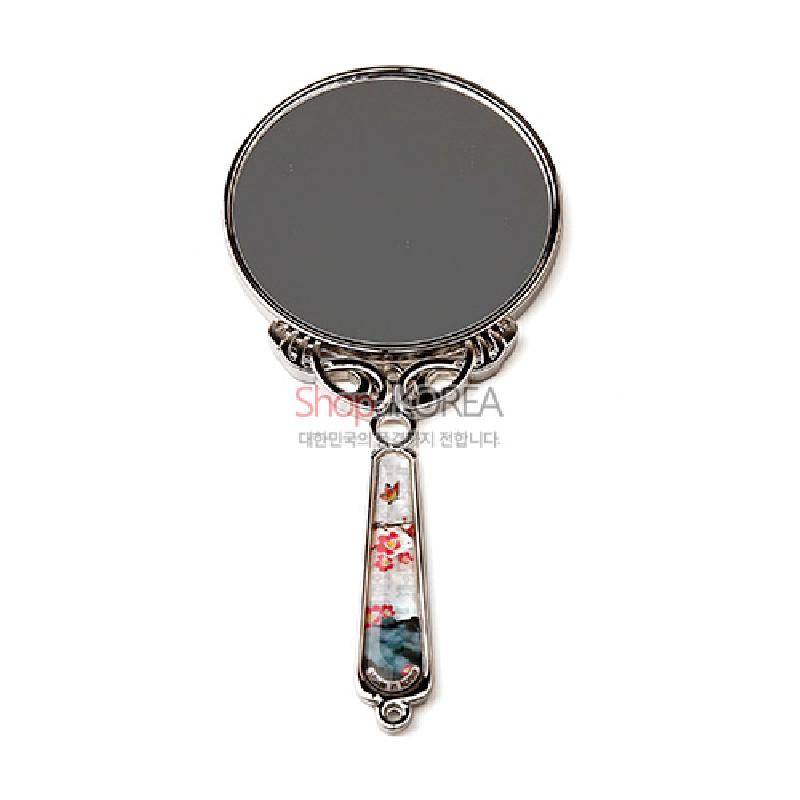 자개 상감 기법으로 손잡이에 꽃과 나비 문양을 넣은 금속 테두리 원형 손거울. 자개 상감 기법으로 손잡이에 꽃과 나비 문양을 넣은 금속 테두리 원형 손거울.