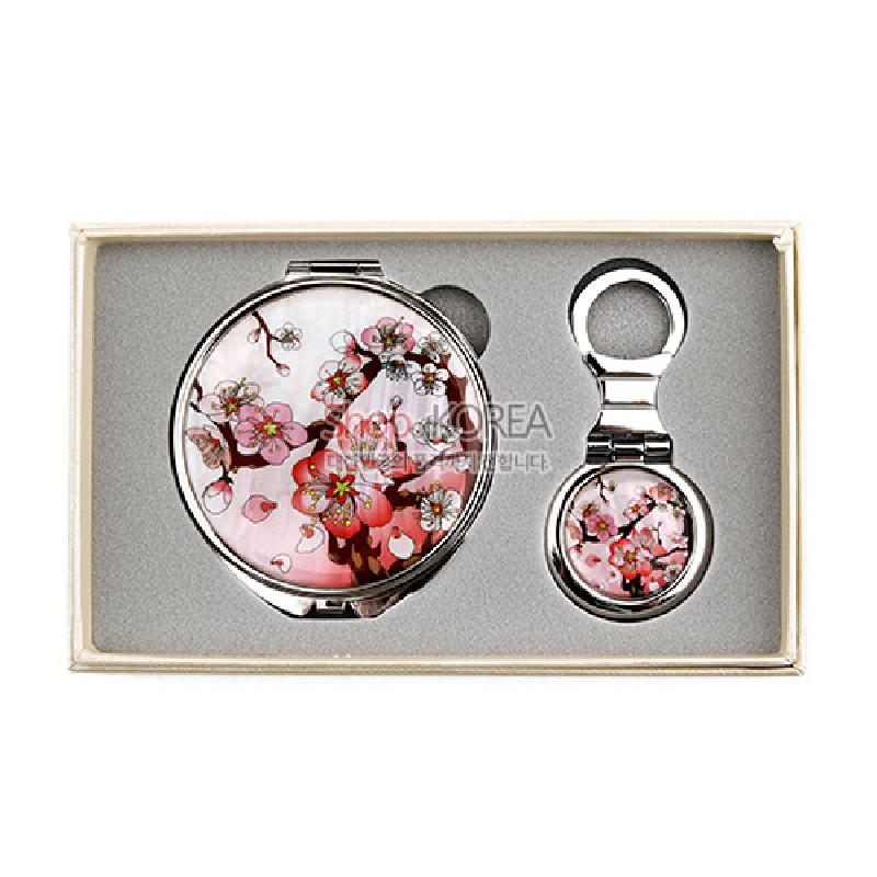 자개와 금속 소재에 옻칠 마감, 분홍과 흰색 매화꽃 문양이 어우러진 원형 손거울과 가방걸이 2종 세트.