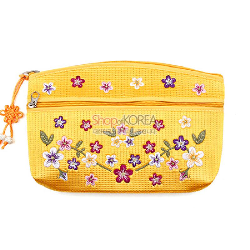 노란색 직조 원단 위 다채로운 배꽃 자수와 잎사귀 문양, 매듭 장식 지퍼 손잡이가 포인트인 파우치.