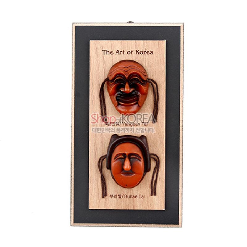 나무 바탕 위에 갈색과 주황색 조화의 하회탈 두 개를 입체 부조로 배치한 세로형 액자.