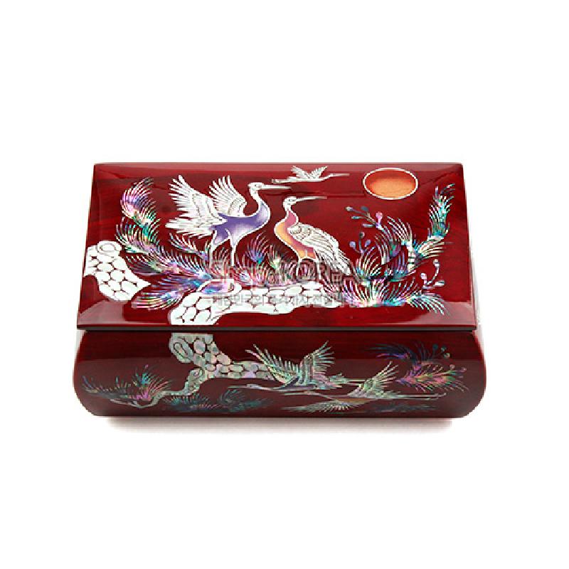 붉은 옻칠 바탕에 자개 상감 기법으로 송학과 해, 소나무 문양을 섬세하게 표현한 반지꽂이 함.